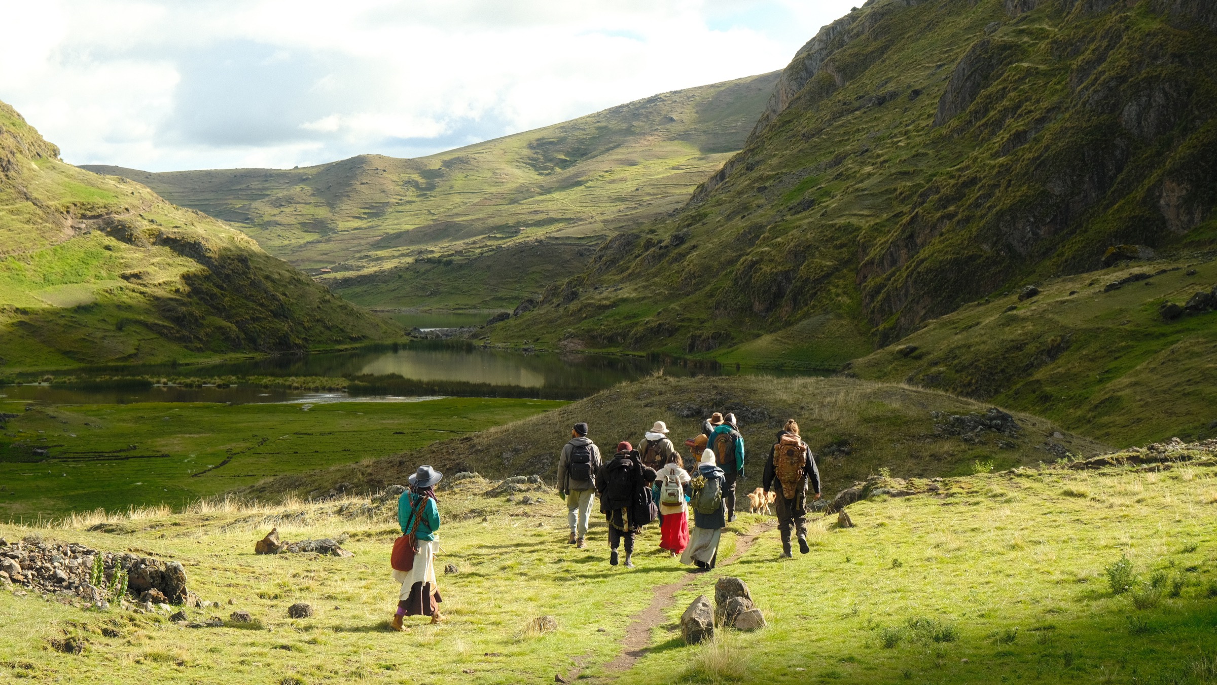 The Psychic Garden group trekking together toward a lake in the Andes